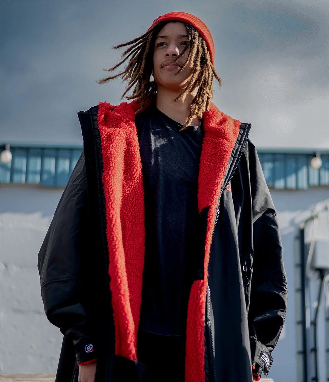 A Black Red Dryrobe Advance worn open, the red fleece lining showing against the black shell