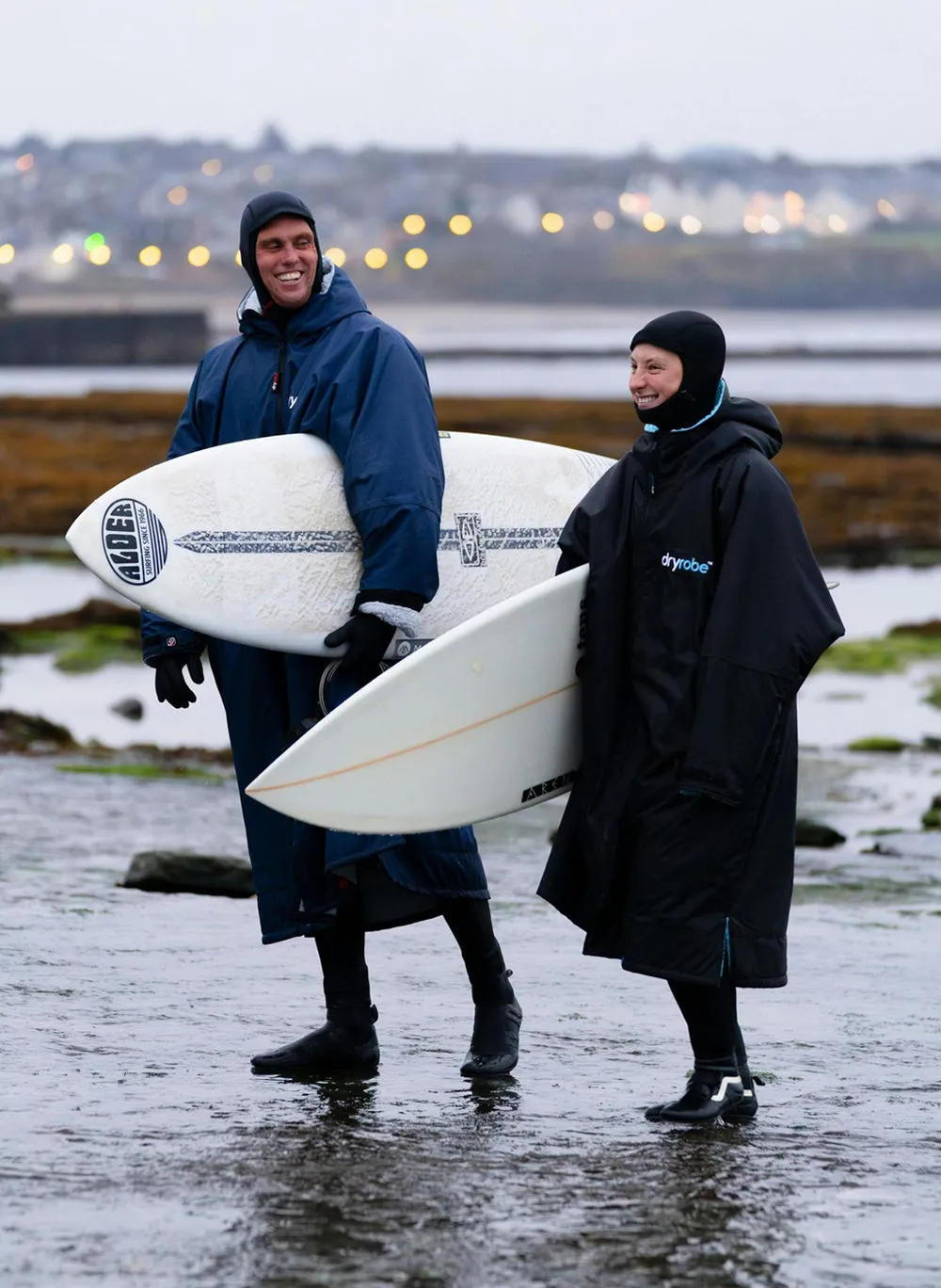 Two adult surfers both wearing Dryrobe® advance long sleeve's at the beach